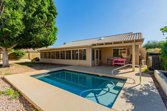 a view of a house with pool and sitting area
