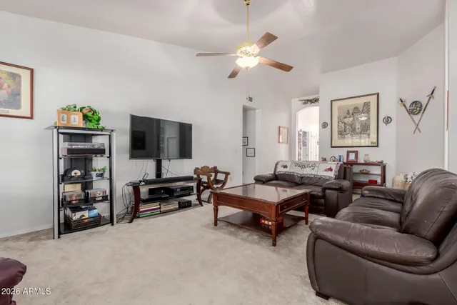 a living room with furniture a chandelier and a flat screen tv