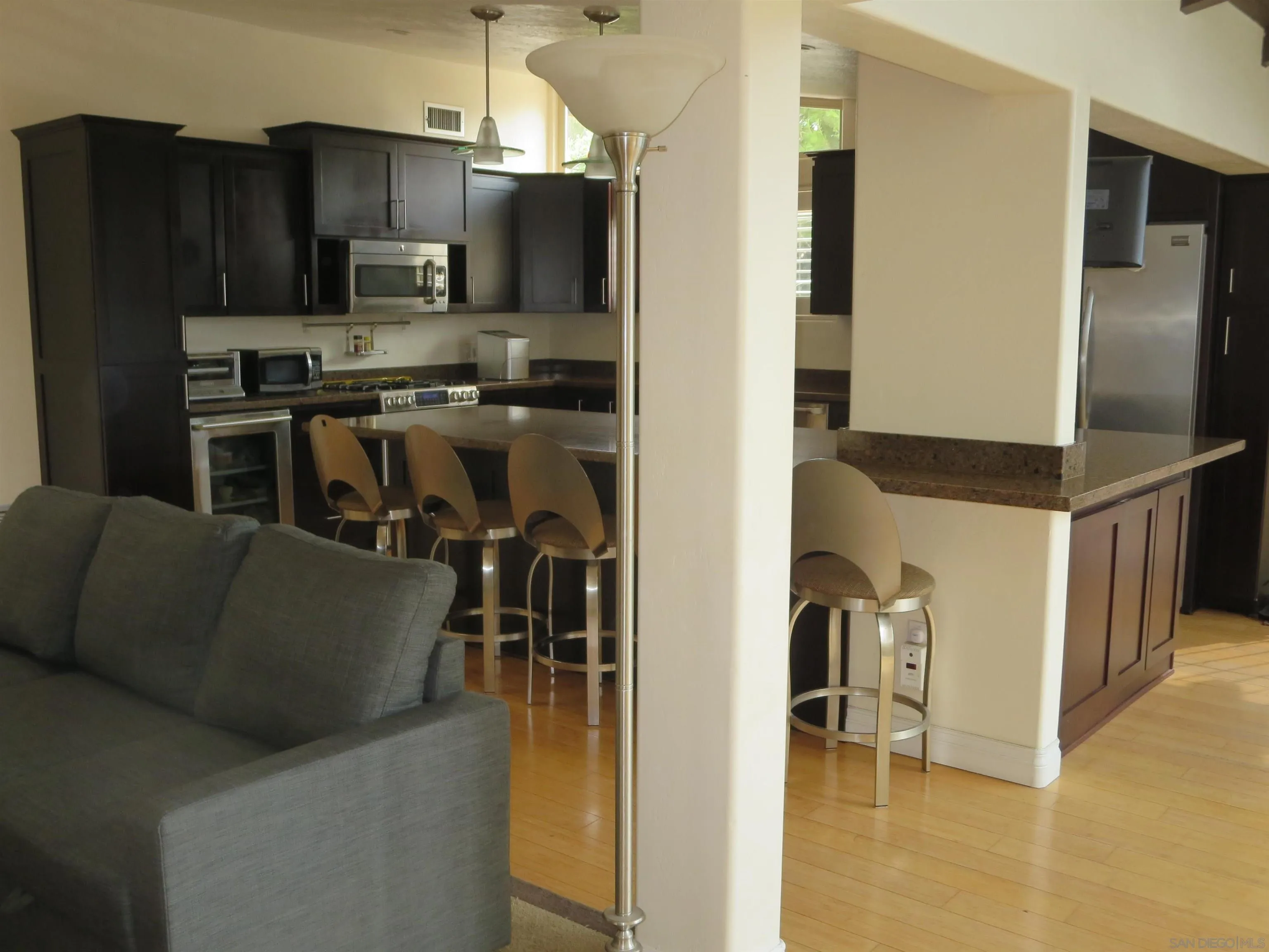 14223 Frame Road Poway, CA 92064 - Photo 9 of 44 a kitchen with stainless steel appliances granite countertop a refrigerator a stove and a sink with wooden floor