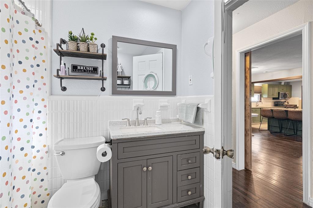 1308 Myrtle Street Denton, TX 76201 - Photo 16 of 35 a bathroom with a toilet a sink and a mirror