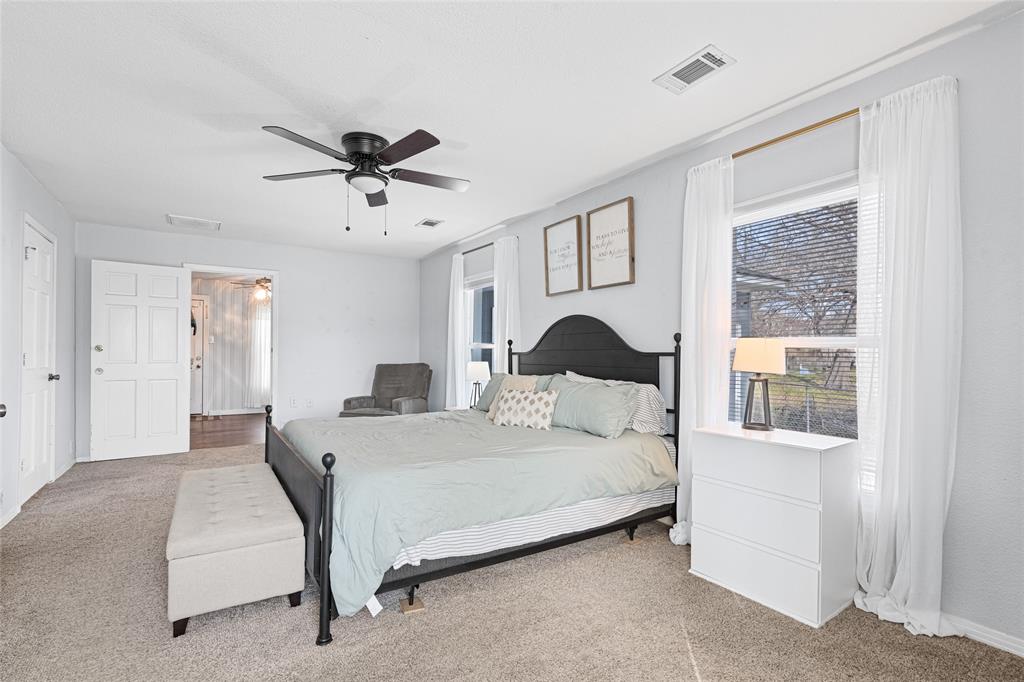 1308 Myrtle Street Denton, TX 76201 - Photo 23 of 35 a bedroom with a bed and a chandelier