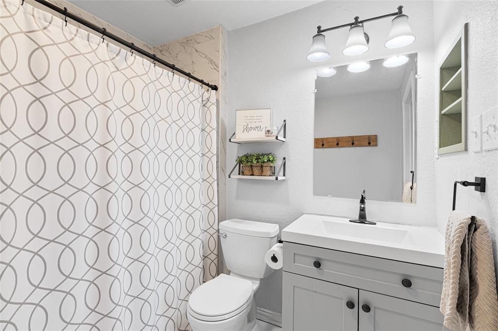 1308 Myrtle Street Denton, TX 76201 - Photo 35 of 35 a bathroom with a sink a toilet and a mirror