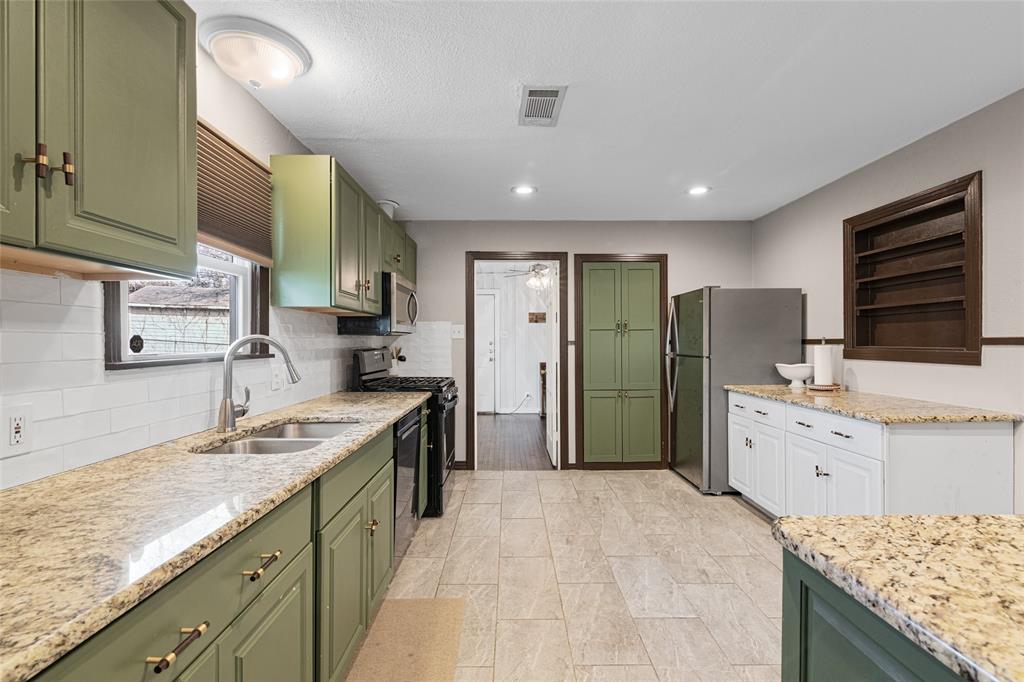 1308 Myrtle Street Denton, TX 76201 - Photo 5 of 35 a kitchen with granite countertop a sink stove refrigerator and cabinets
