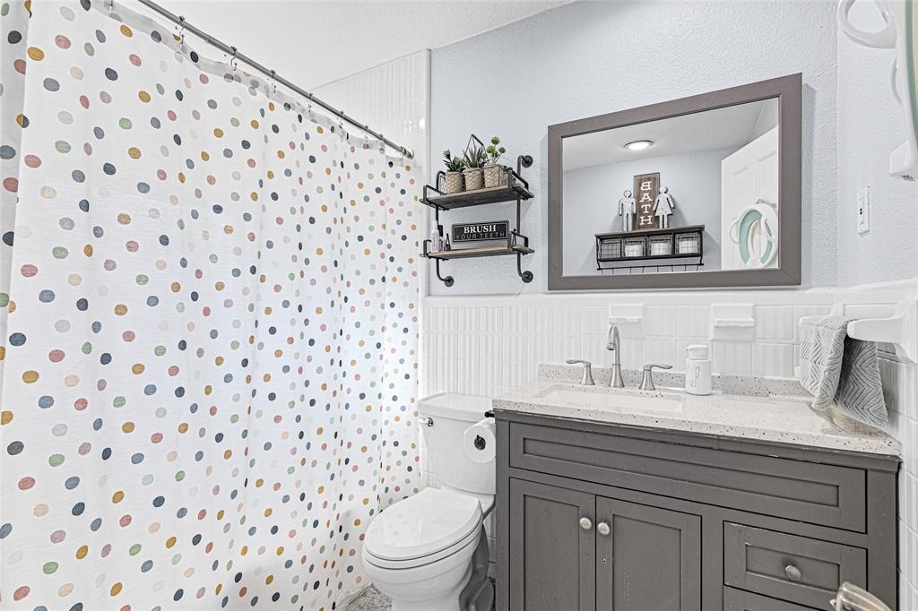 1308 Myrtle Street Denton, TX 76201 - Photo 6 of 35 a bathroom with a sink a toilet and a mirror