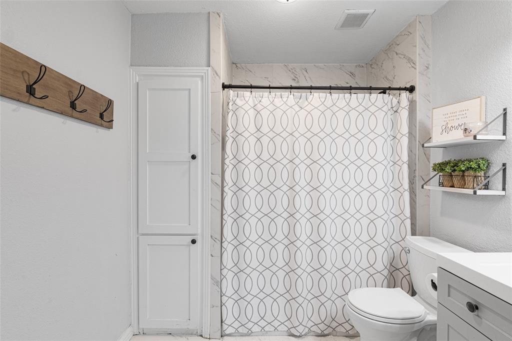 1308 Myrtle Street Denton, TX 76201 - Photo 8 of 35 a white toilet sitting next to a shower curtain