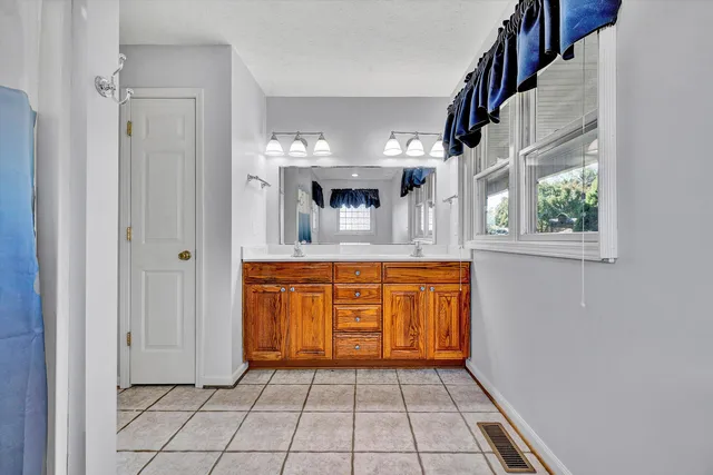 a view of a hallway with wooden floor and a bathroom