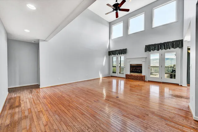 a view of an empty room with window and wooden floor