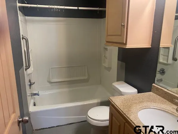 a bathroom with a granite countertop sink toilet and shower