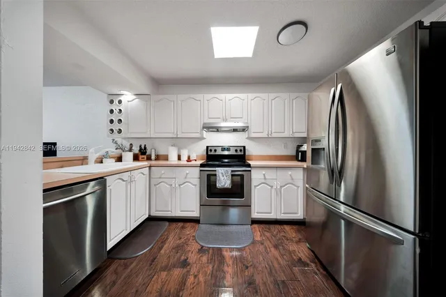 a kitchen with a refrigerator stove and wooden cabinets