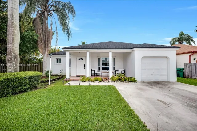 front view of a house with a yard and potted plants