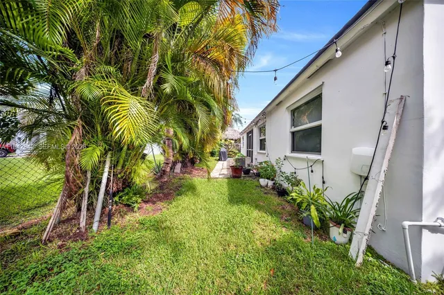 a backyard of a house with plants and entertaining space