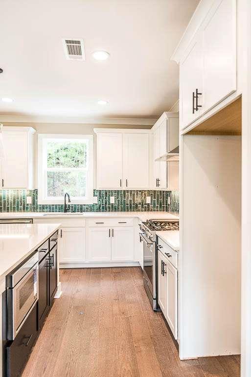 2545 Waldrop Ridge Court Decatur, GA 30034 - Photo 5 of 31 a kitchen with stainless steel appliances a white cabinets and wooden floor