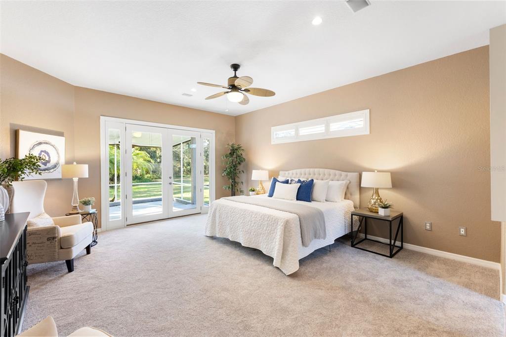 12305 Twin Branch Acres Road Tampa, FL 33626 - Photo 16 of 66 a spacious bedroom with a bed and a chandelier