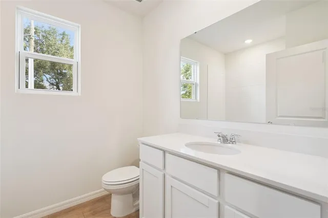 a bathroom with a sink toilet and a window