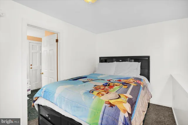 a bedroom with a bed and painting on the wall