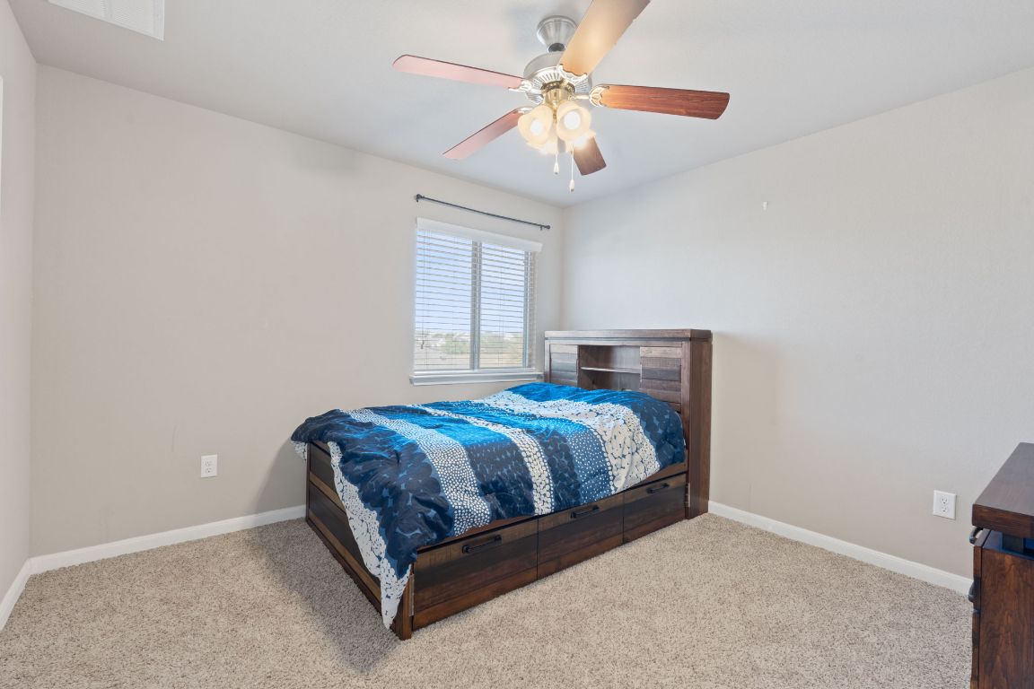 608 Palo Duro Loop Round Rock, TX 78664 - Photo 20 of 28 a bedroom with a bed and a chandelier