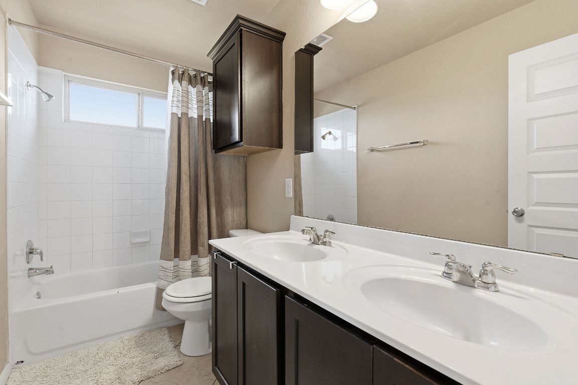 608 Palo Duro Loop Round Rock, TX 78664 - Photo 22 of 28 a bathroom with a double vanity sink toilet mirror and bathtub