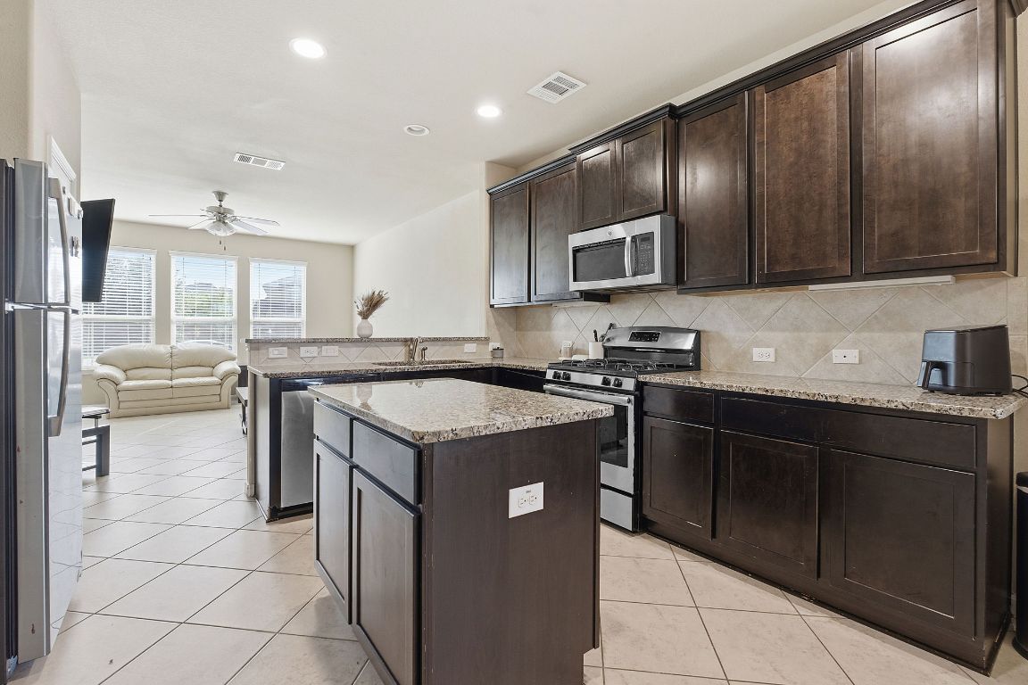 608 Palo Duro Loop Round Rock, TX 78664 - Photo 4 of 28 a kitchen with granite countertop stainless steel appliances and wooden cabinets
