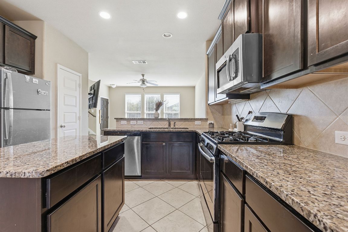 608 Palo Duro Loop Round Rock, TX 78664 - Photo 5 of 28 a kitchen with stainless steel appliances granite countertop a stove a sink and a refrigerator