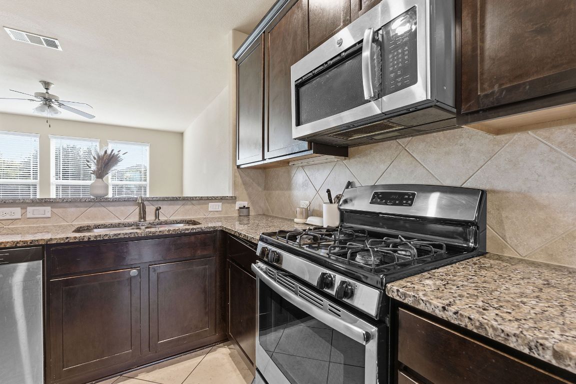 608 Palo Duro Loop Round Rock, TX 78664 - Photo 6 of 28 a kitchen with stainless steel appliances granite countertop a stove and a microwave