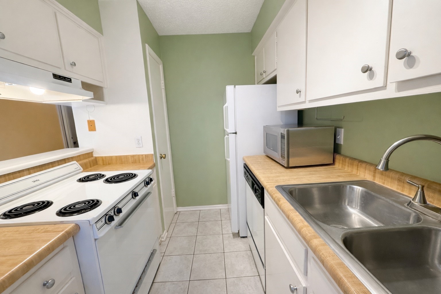 8223 Kingsbrook Road, Unit 215 Houston, TX 77024 - Photo 9 of 20 Kitchen features a double sink, refrigerator, dishwasher, ample cabinet space, microwave, and a pantry.