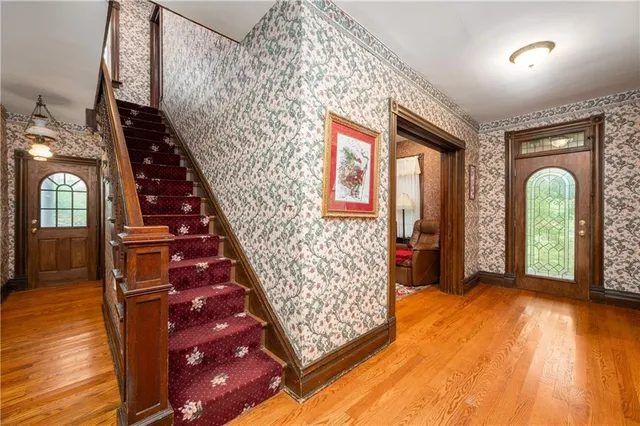 a view of a hallway with wooden floor windows and a chandelier