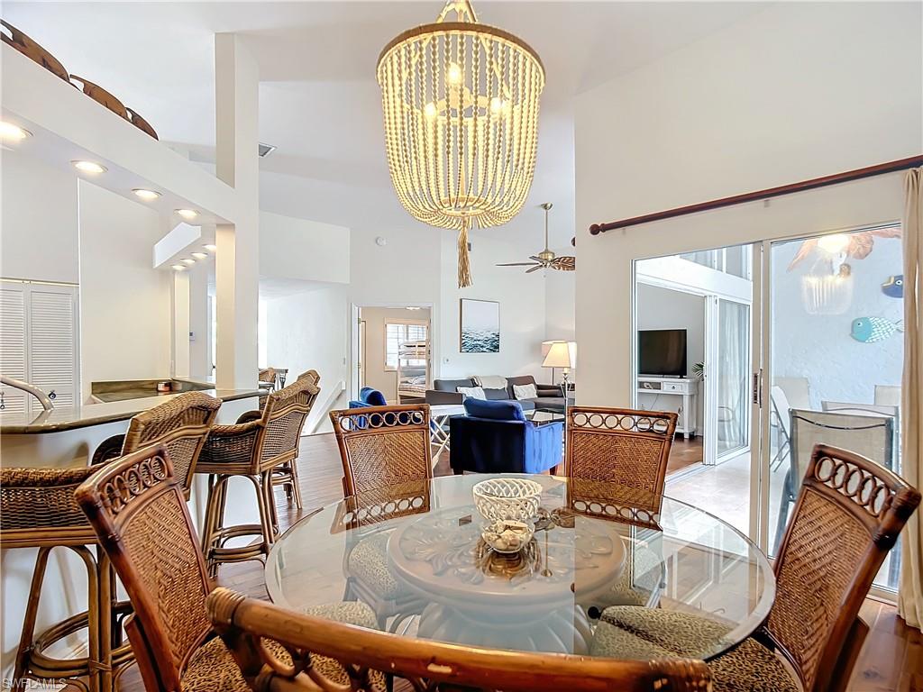 2860 Citrus Lake Drive, Unit R202 Naples, FL 34109 - Photo 20 of 50 a dining room with furniture a chandelier and wooden floor