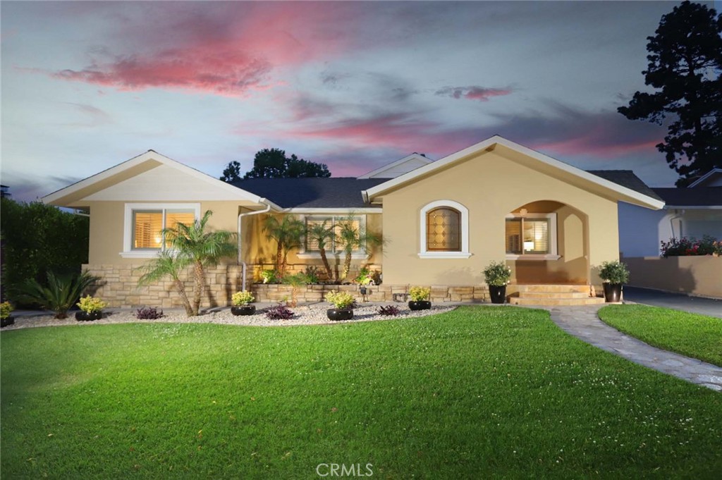 a front view of a house with a garden and yard