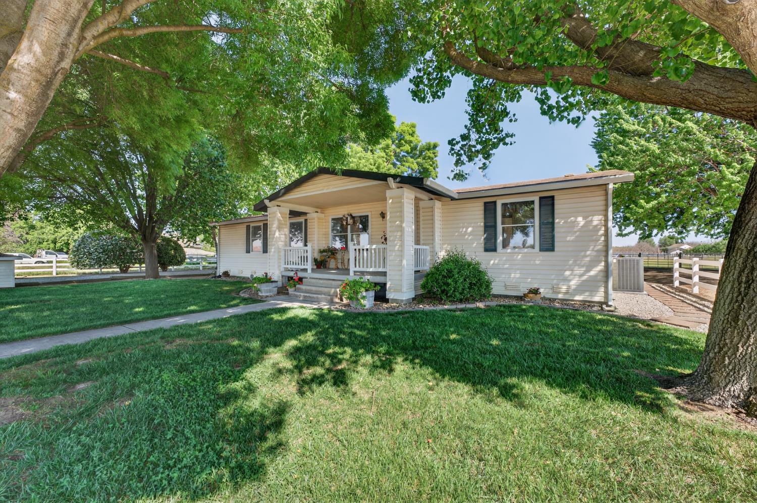 a front view of a house with yard and green space