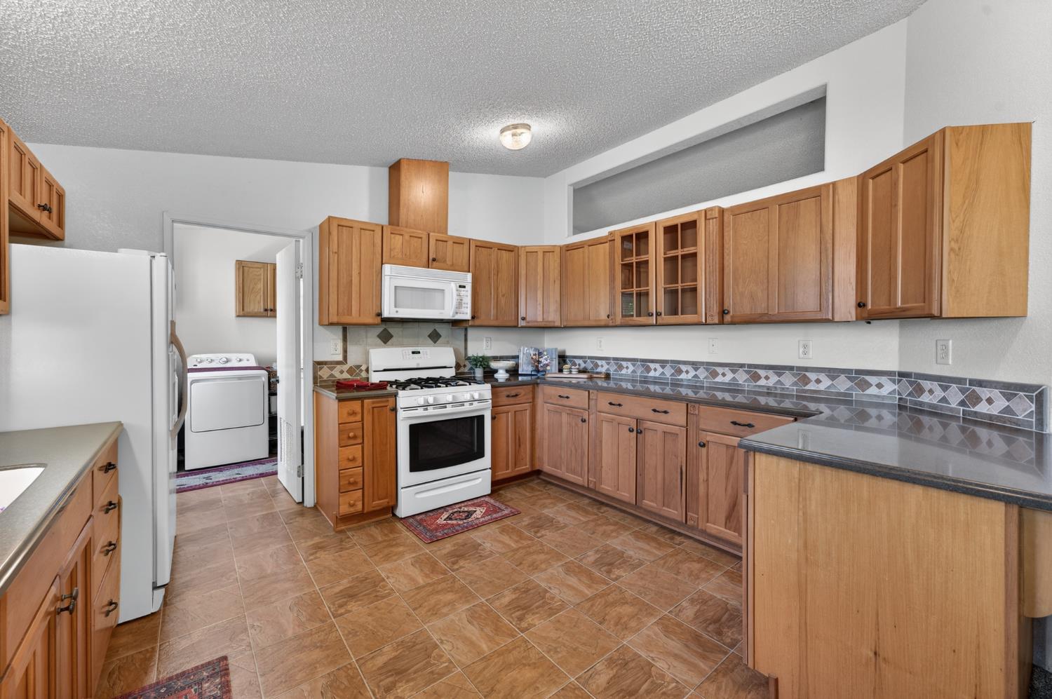 2450 George Road Williams, CA 95987 - Photo 24 of 43 a kitchen with granite countertop a refrigerator stove top oven and sink