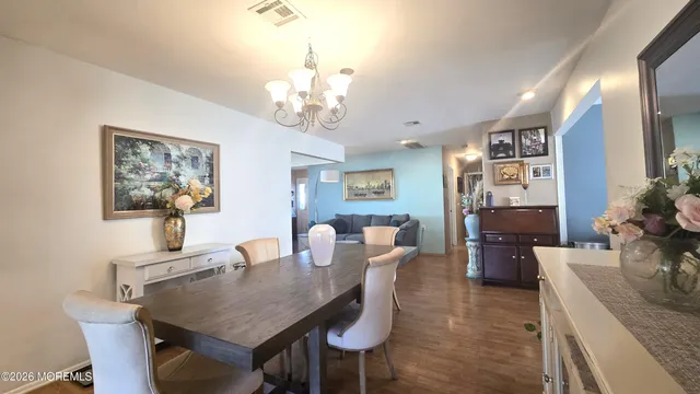 a view of a dining room with furniture a chandelier and wooden floor
