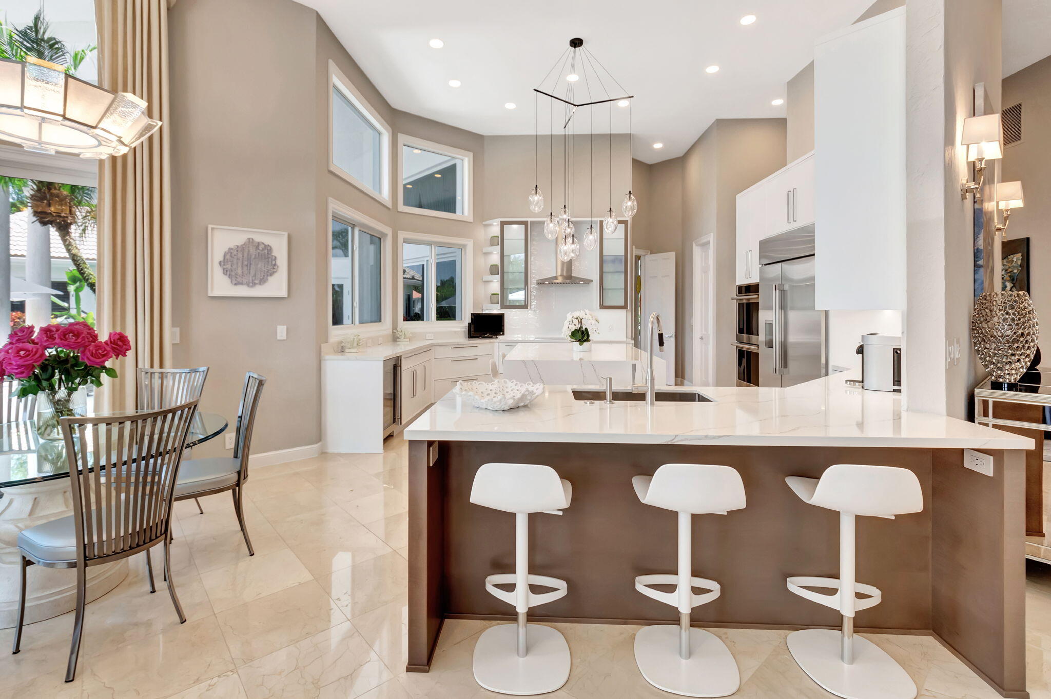 2599 Northwest 63rd Lane Boca Raton, FL 33496 - Photo 18 of 81 a kitchen with stainless steel appliances granite countertop a dining table chairs and white cabinets