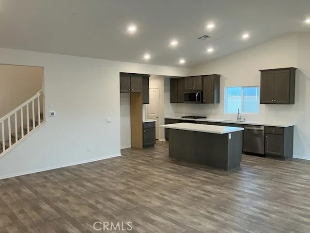 a large kitchen with stainless steel appliances granite countertop a stove a sink and a microwave