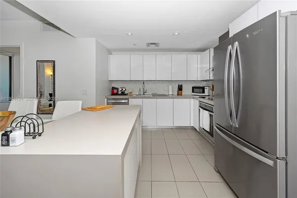 a kitchen with granite countertop a refrigerator and a sink