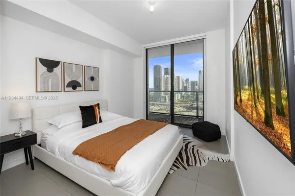 a bedroom with a bed and a large window