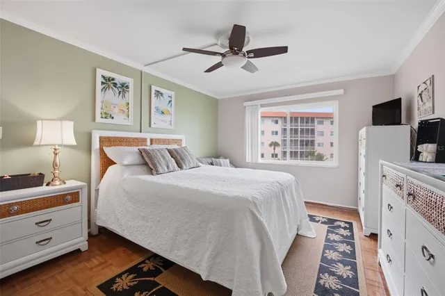 a bedroom with a bed and a flat tv screen on dresser