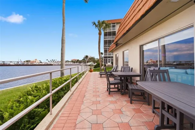 a view of a balcony with chairs potted plants with wooden floor and fence