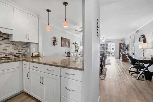 a kitchen with white cabinets and chairs