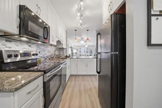 a kitchen with stainless steel appliances granite countertop a refrigerator and a stove