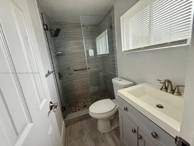 a bathroom with a sink a toilet and a shower