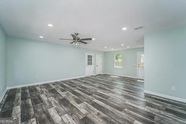 a view of a livingroom with a ceiling fan and window