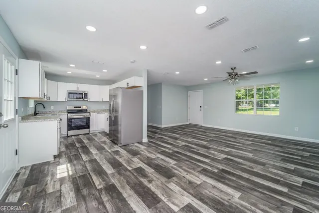 a kitchen with stainless steel appliances granite countertop a refrigerator and a sink