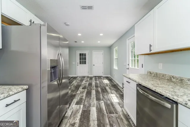 a kitchen with stainless steel appliances granite countertop a stove a sink and a microwave