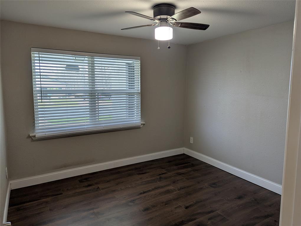 100 West Hull Street Denison, TX 75021 - Photo 11 of 28 an empty room with wooden floor and windows
