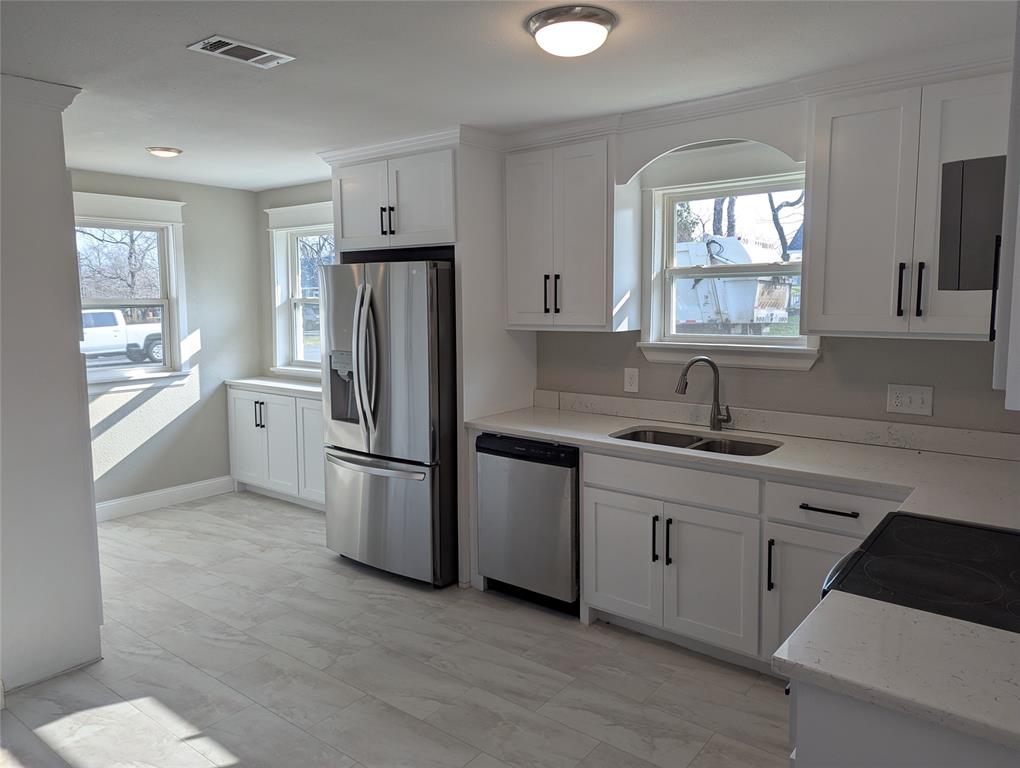 100 West Hull Street Denison, TX 75021 - Photo 6 of 28 a kitchen with stainless steel appliances a refrigerator sink and cabinets