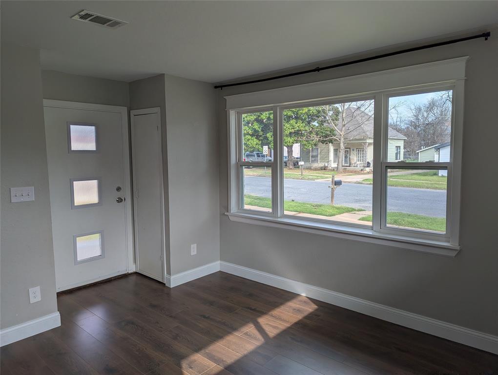 100 West Hull Street Denison, TX 75021 - Photo 9 of 28 an empty room with wooden floor and windows