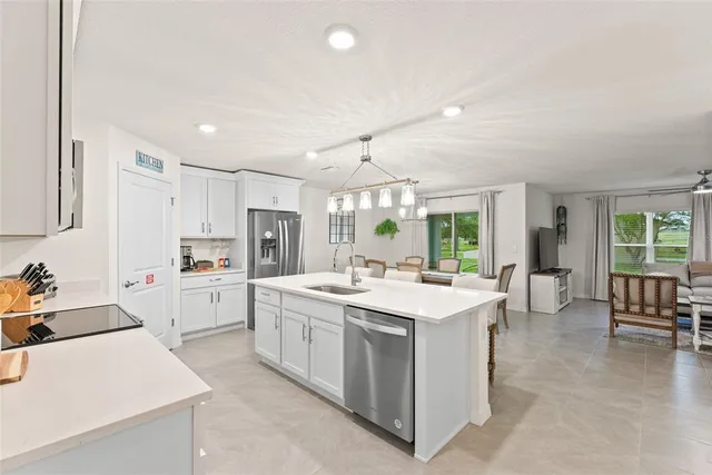 a kitchen with stainless steel appliances a table chairs and refrigerator