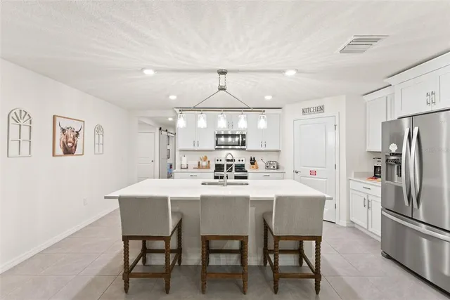 a kitchen with a table chairs and a large window