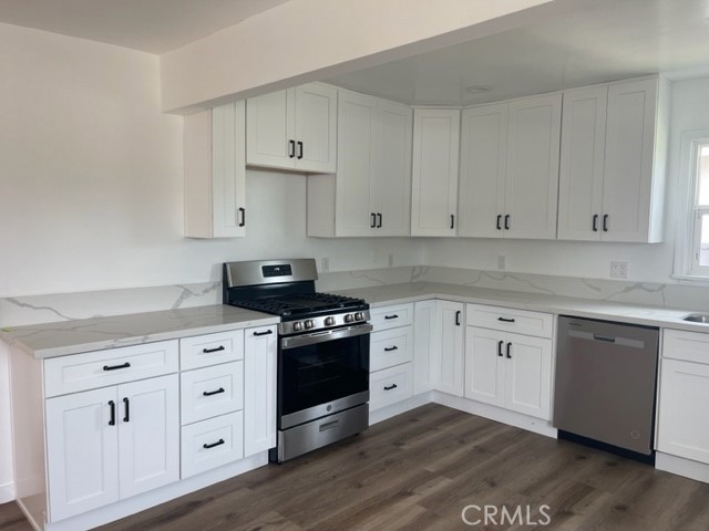 19550 Vanowen Street Reseda, CA 91335 - Photo 4 of 10 a kitchen with granite countertop white cabinets and stainless steel appliances
