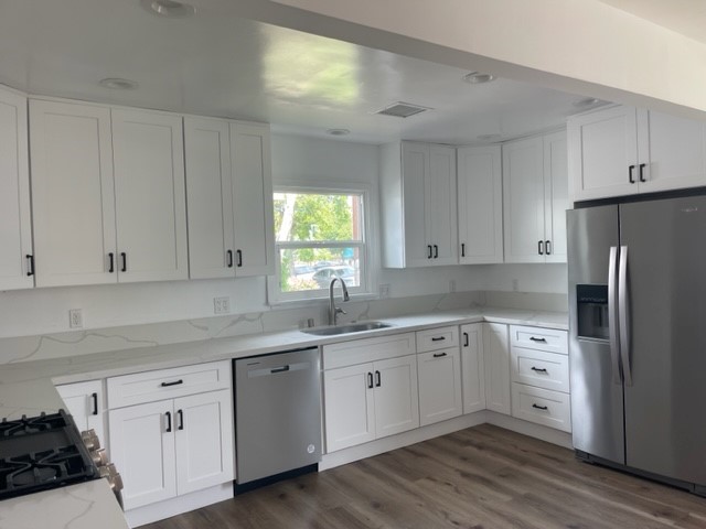 19550 Vanowen Street Reseda, CA 91335 - Photo 5 of 10 a kitchen with white cabinets sink and refrigerator